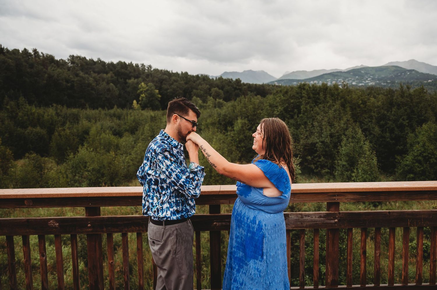 A row of photos shows people enjoying views from a wooden deck railing overlooking a forested mountain landscape.