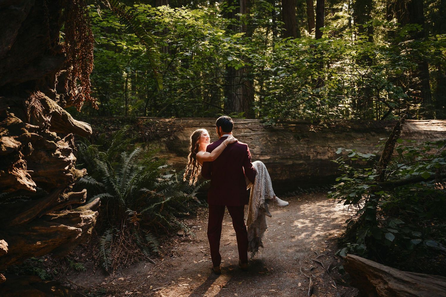 Wedding couple walking together through a majestic redwood forest in Northern California.
