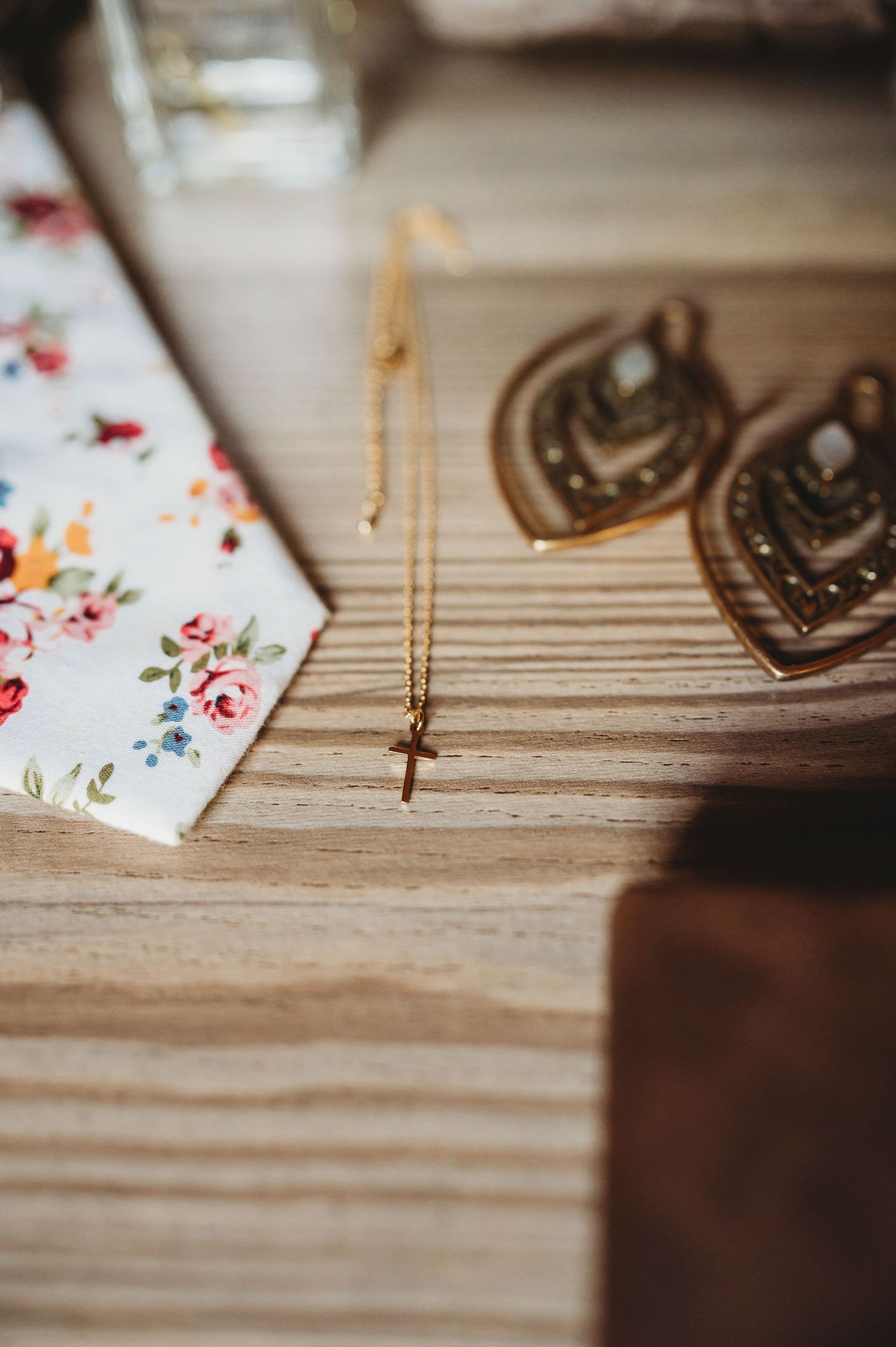 Decorative wedding accessories and jewelry arranged on a rustic wooden surface.