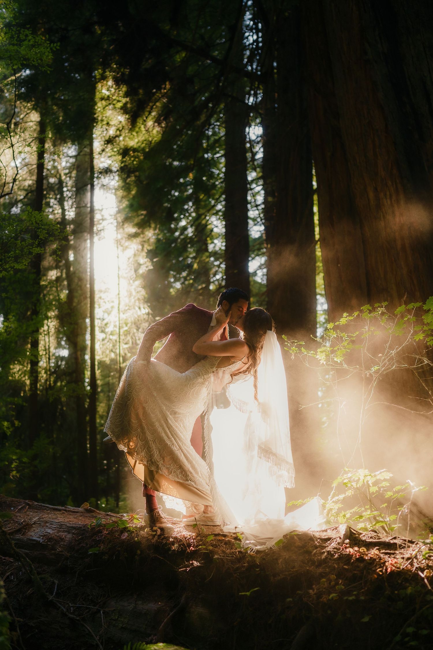 A dreamy wedding photoshoot in a sunlit forest with lens flares creating a magical ethereal atmosphere.