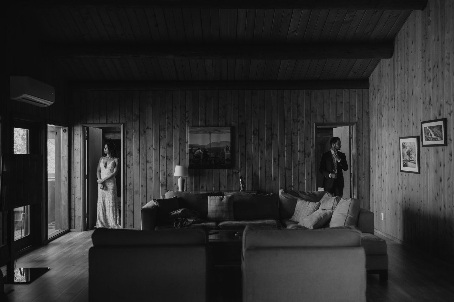 Interior shot of an empty dance hall with wooden walls and dramatic shadows from overhead lighting.