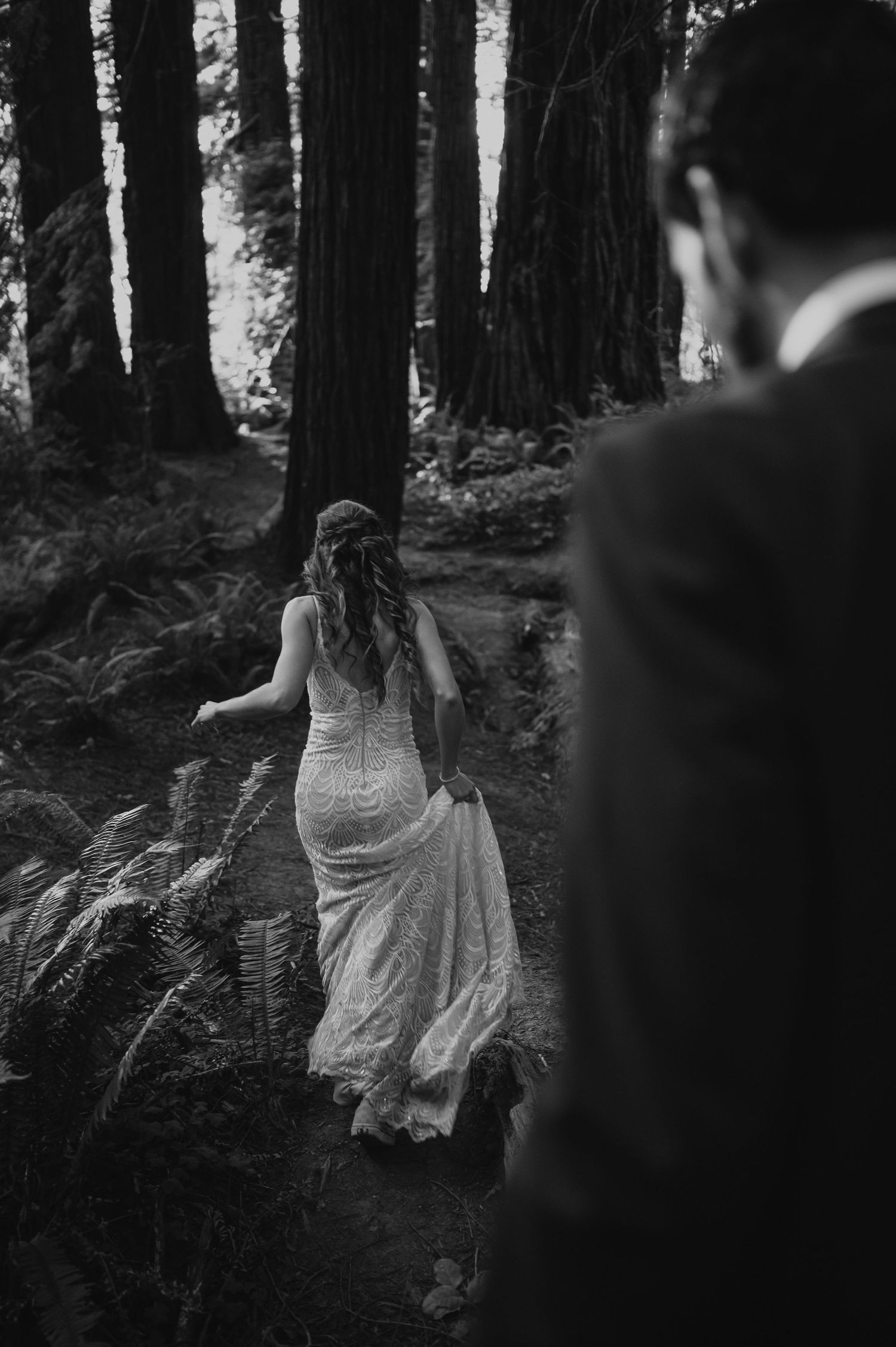 A figure in a white dress moves mysteriously through a dark misty forest creating an ethereal scene.