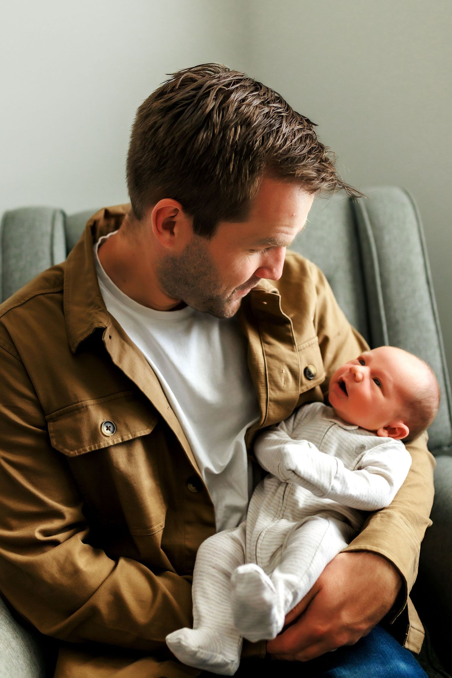 Newborn photography at home in Calgary with dad holding his baby close.