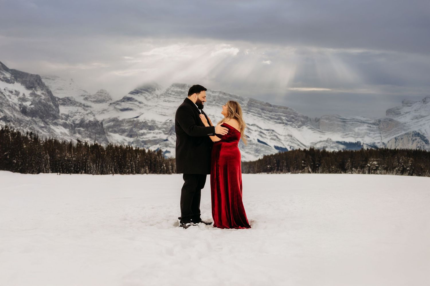 Winter surprise proposal at Two Jack Lake in Banff, Alberta, featuring a couple surrounded by snow-covered mountains.