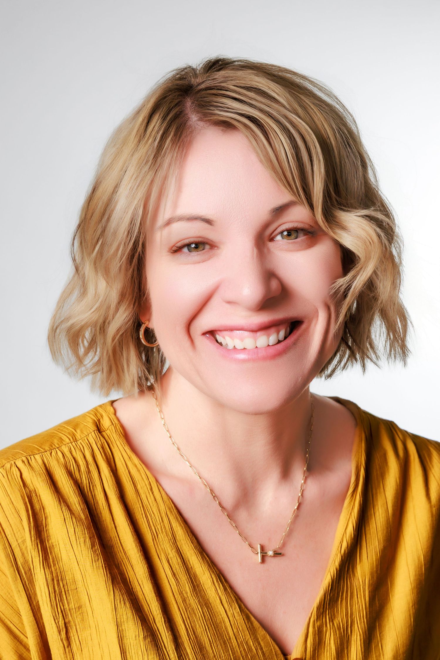 A series of four headshots showing someone with blonde hair wearing a mustard yellow top smiling at the camera.
