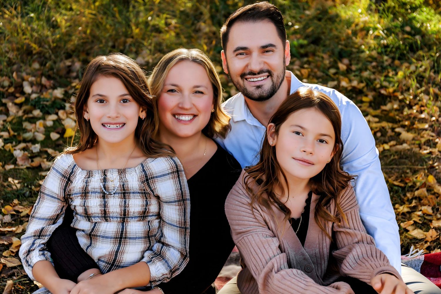 Calgary fall family photography session at Carburn Park featuring a family surrounded by autumn colours and golden light.