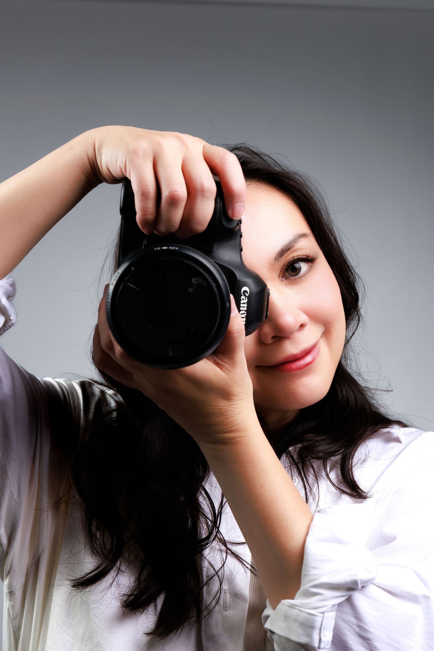 Calgary photographer Vendredi Phan of Doce Photography holding a Canon camera during a photo session