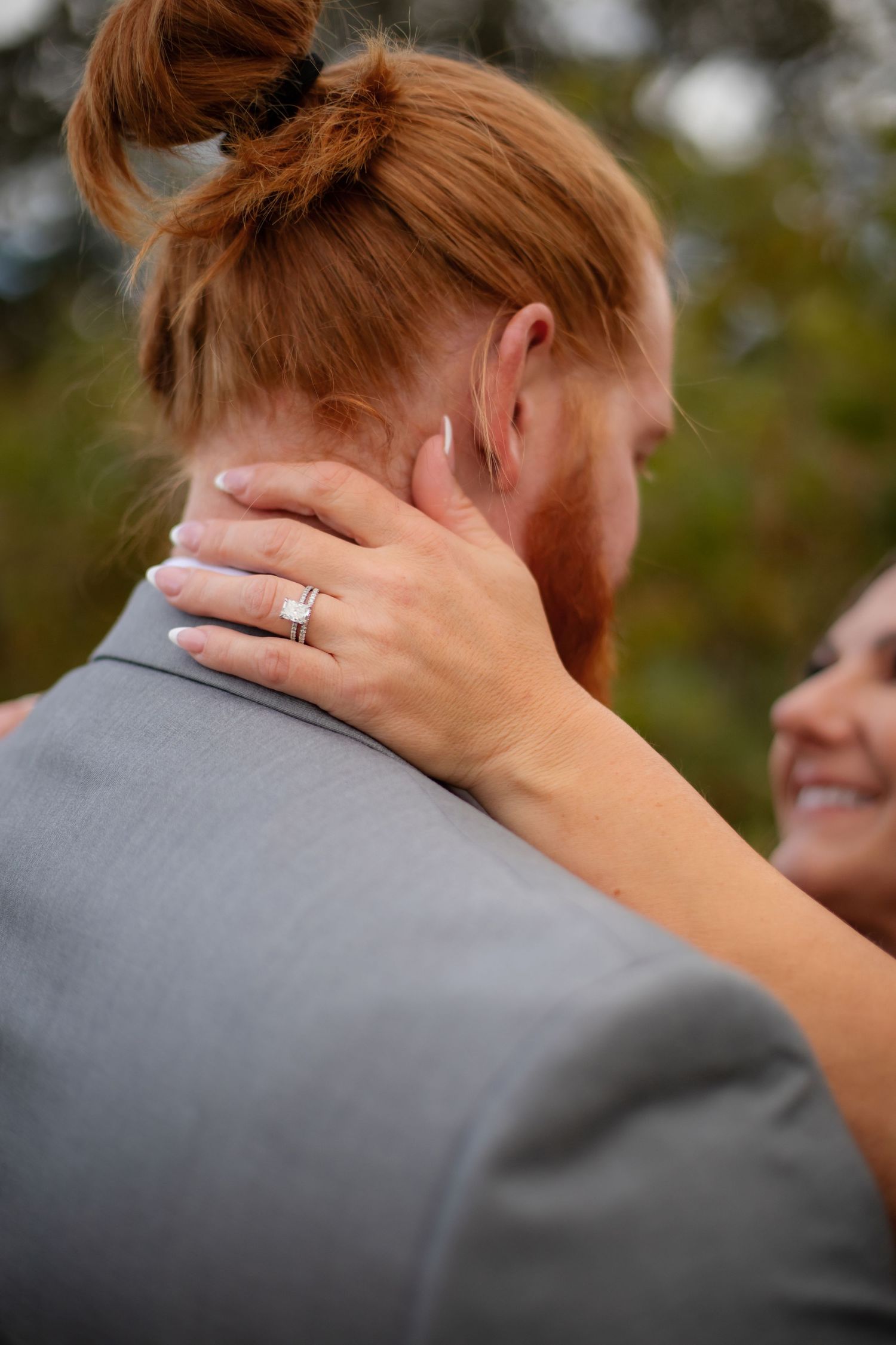 Close-up detail shots of a tender moment between newlyweds with focus on hands and ring.
