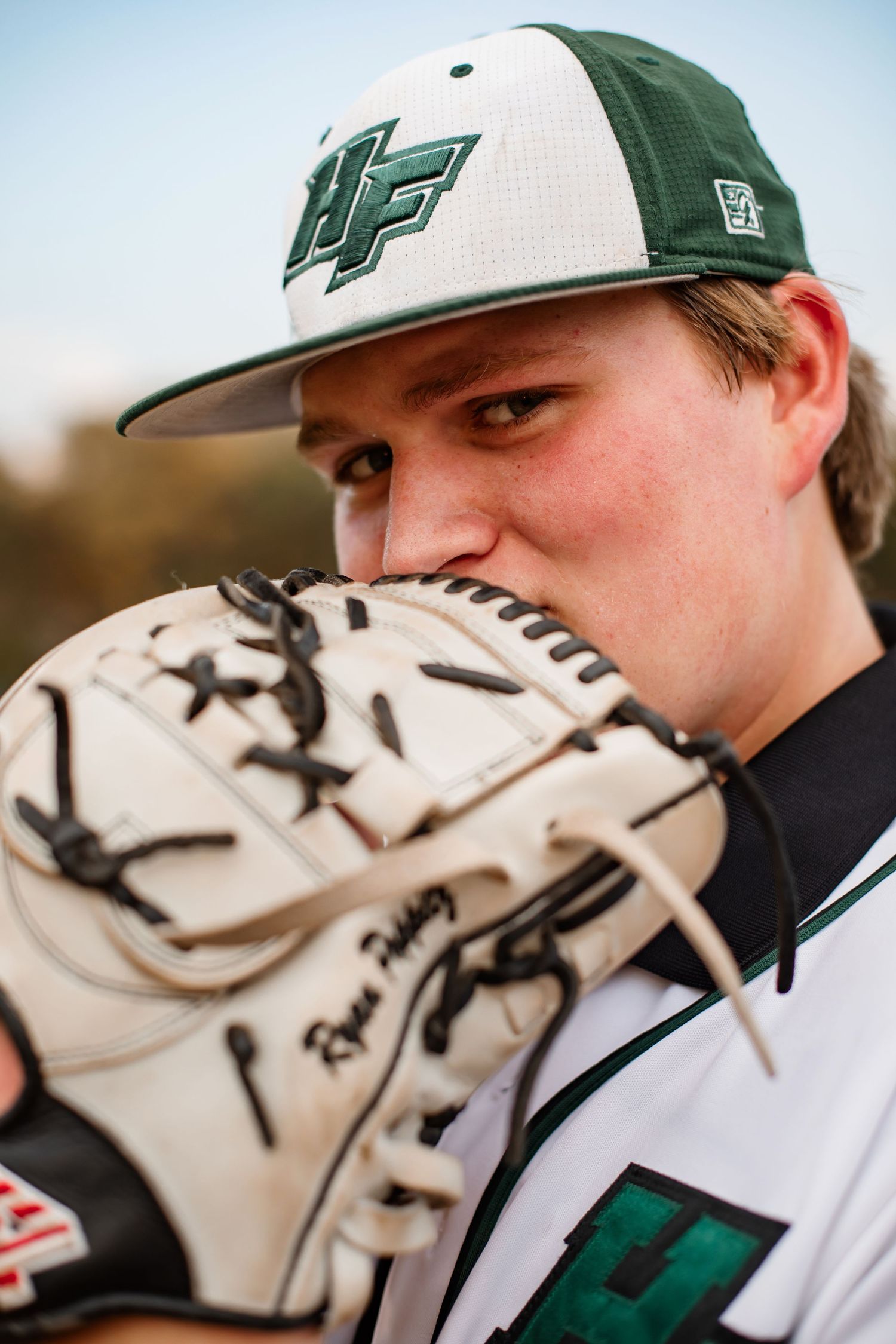 Close-up shot of baseball player with baseball glove wearing UF cap.