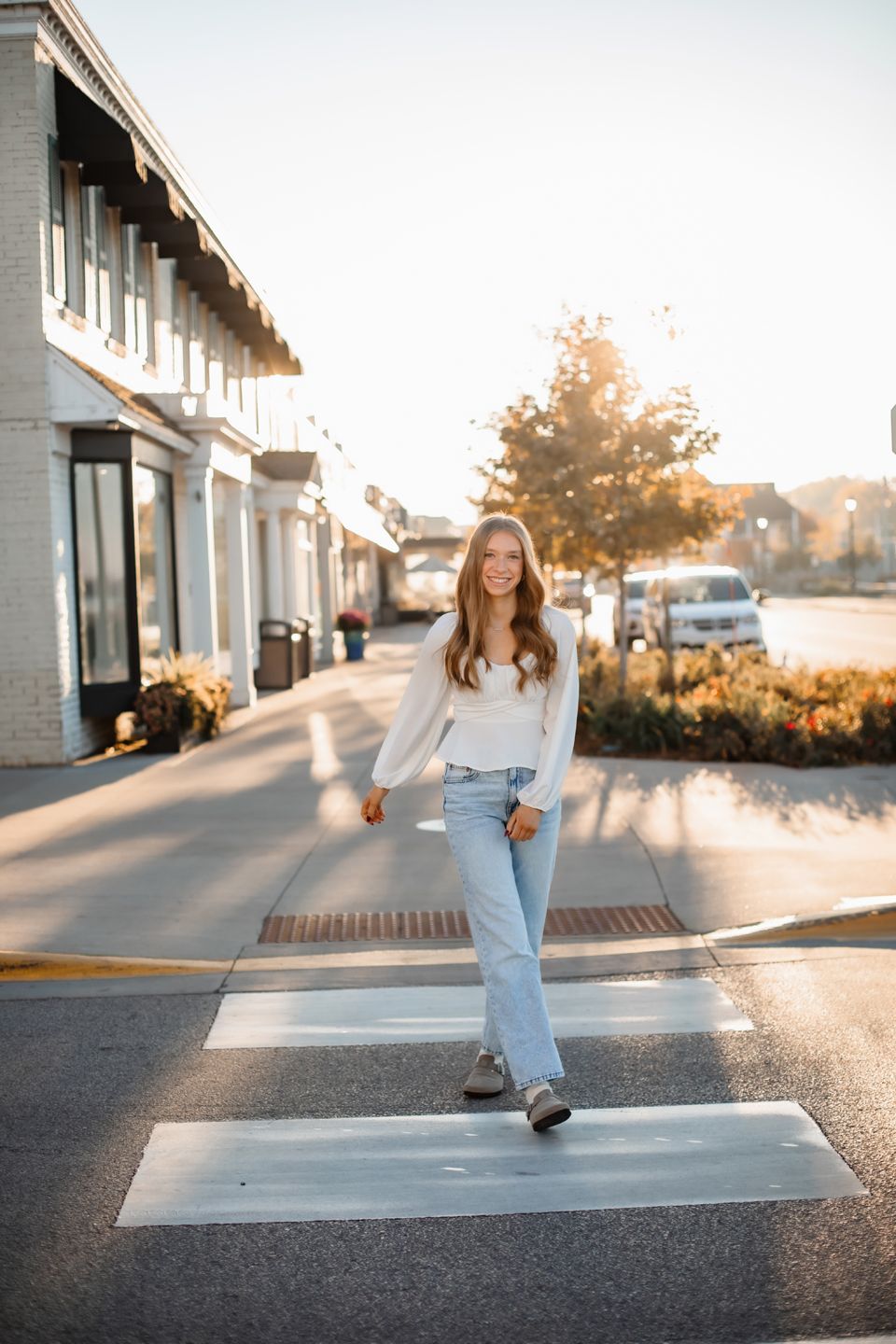 Casual streetwear look captured on crosswalk during golden hour with urban backdrop.