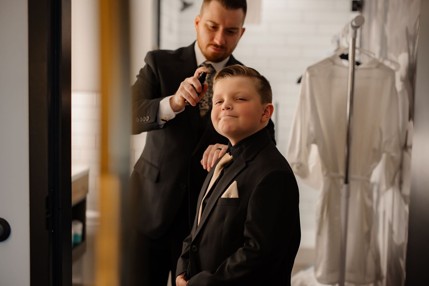 Final adjustments being made to formal attire in preparation room.