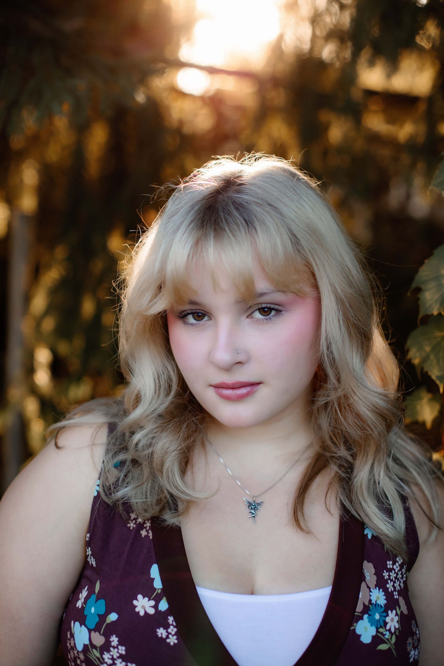 Close-up portrait with golden sunset lighting through trees.