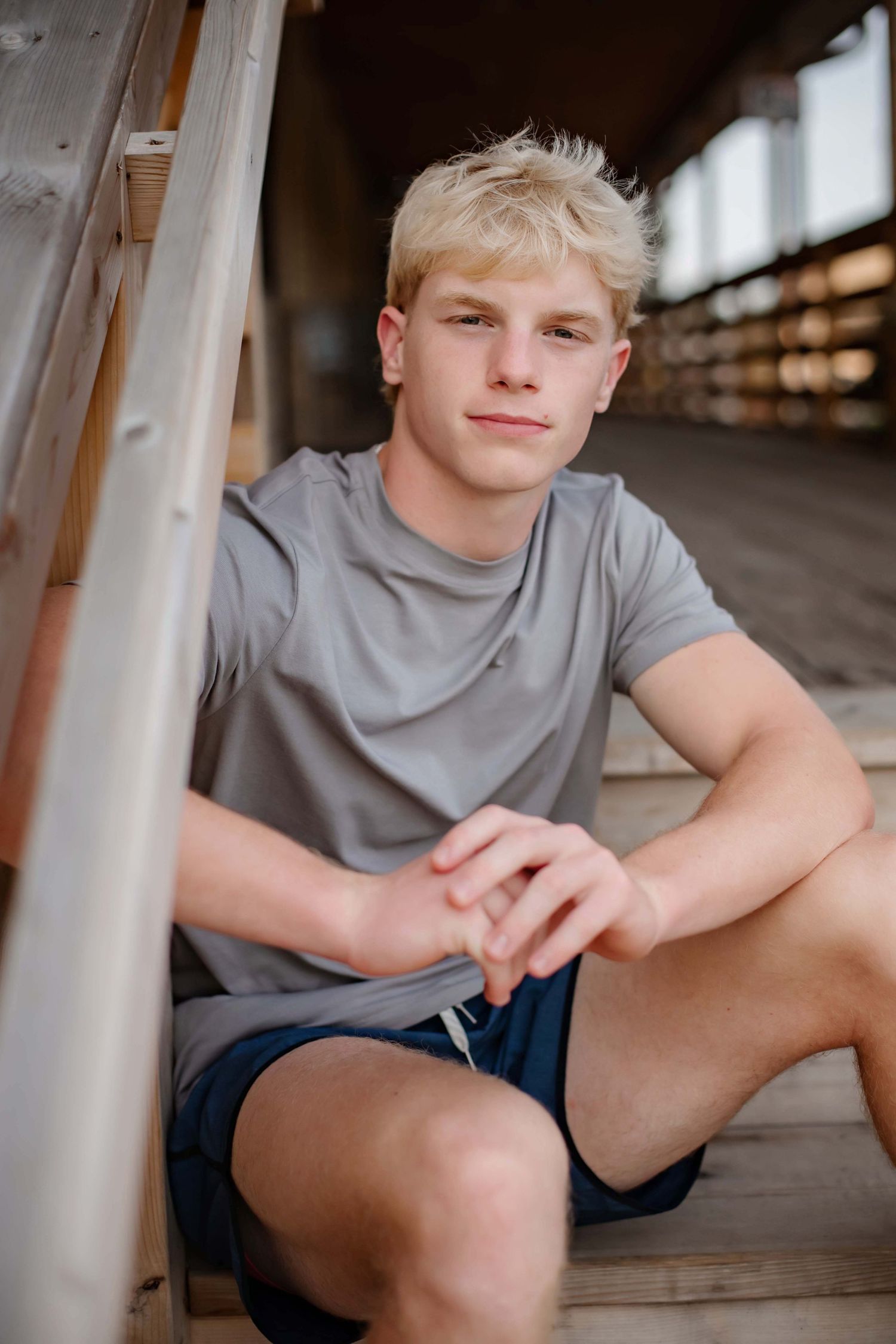 Person in comfortable summer attire seated on wooden steps.