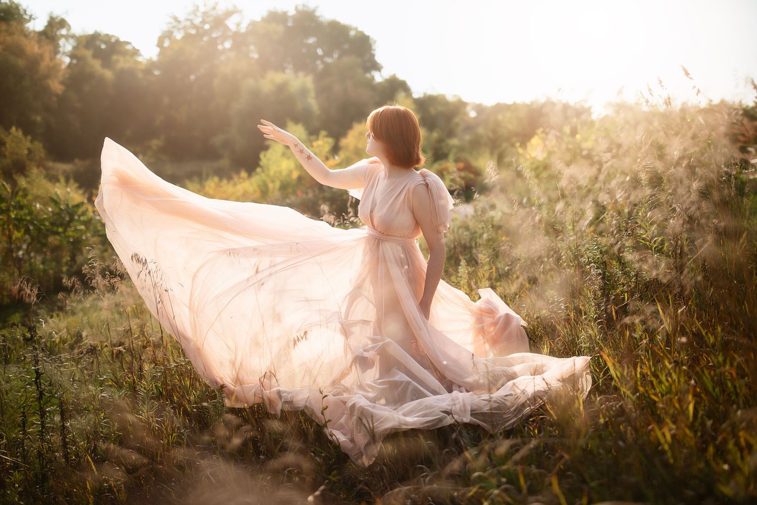 Ethereal figure in flowing pink dress dances in sunlit meadow.