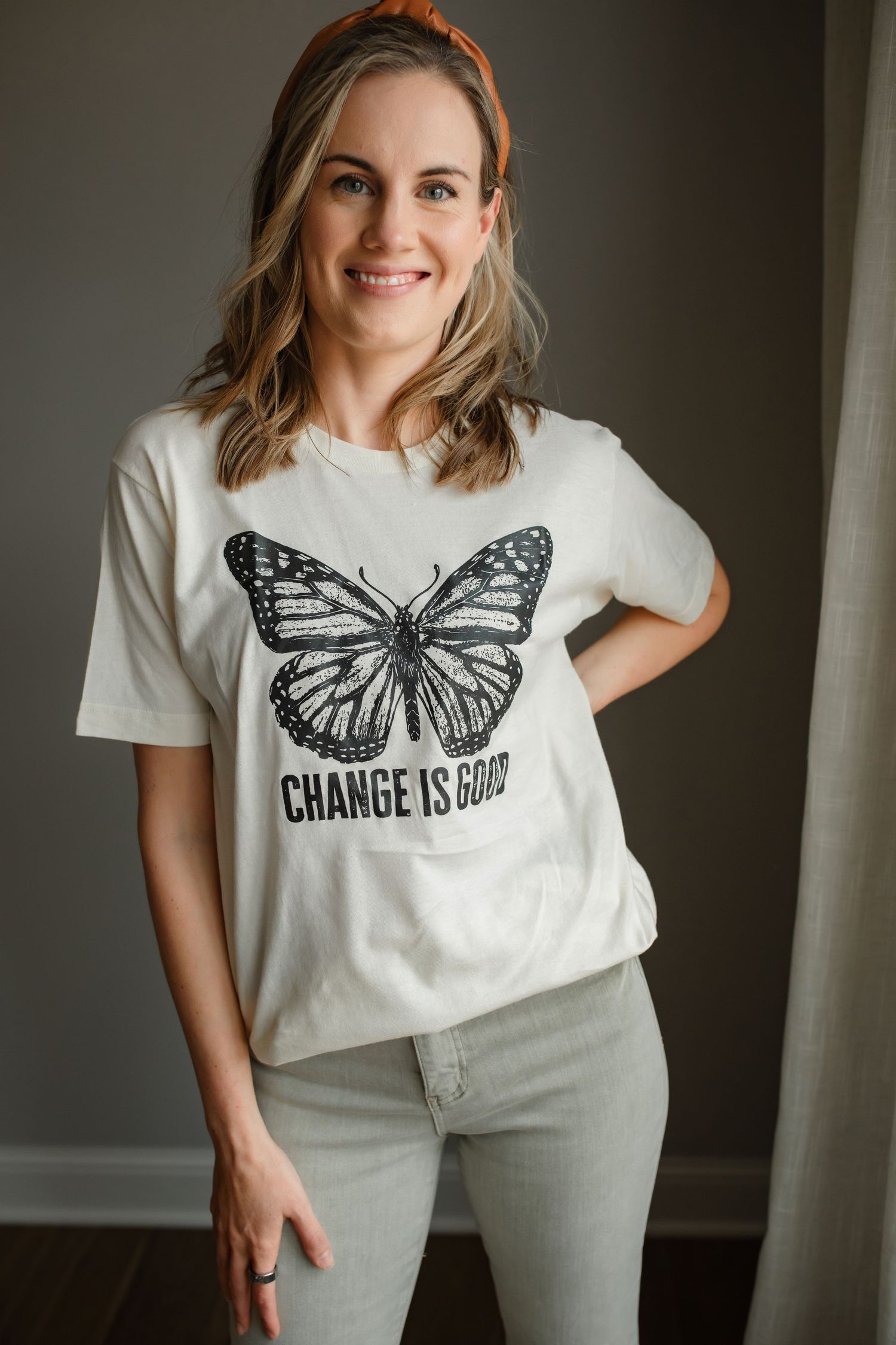 White t-shirt with butterfly graphic and 'Change is Good' text styled with casual denim.