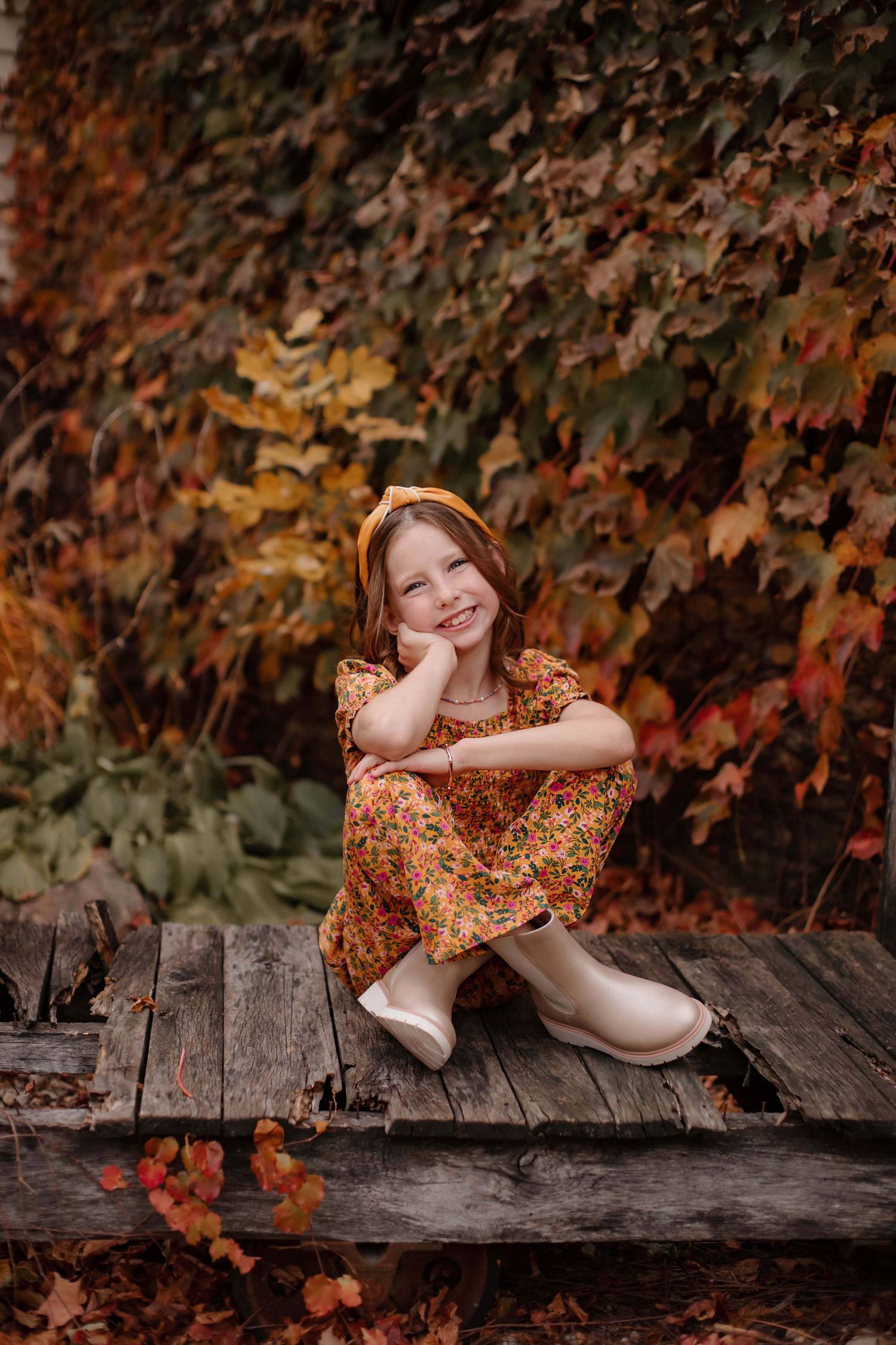 Autumn portrait on wooden deck with colorful fall foliage background.