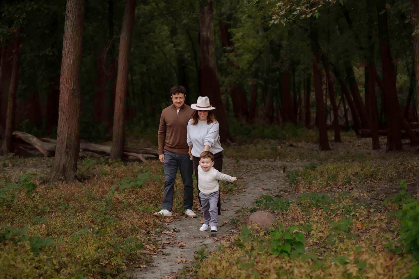 A small group walks together along a wooded trail during autumn.