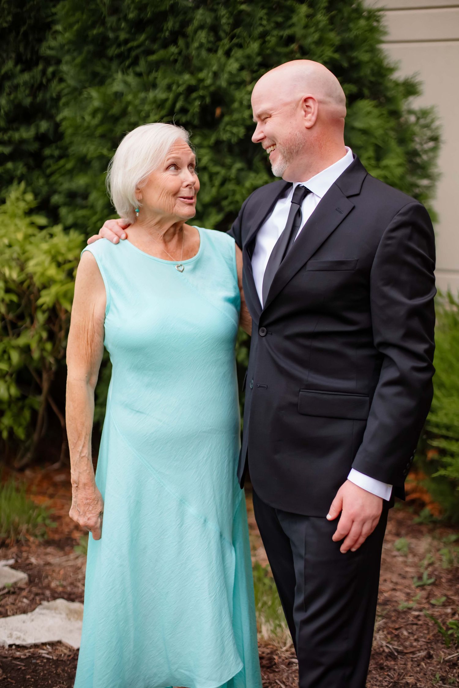 A series of candid moments between a couple in formal attire, with her wearing a mint green dress and him in a black suit.
