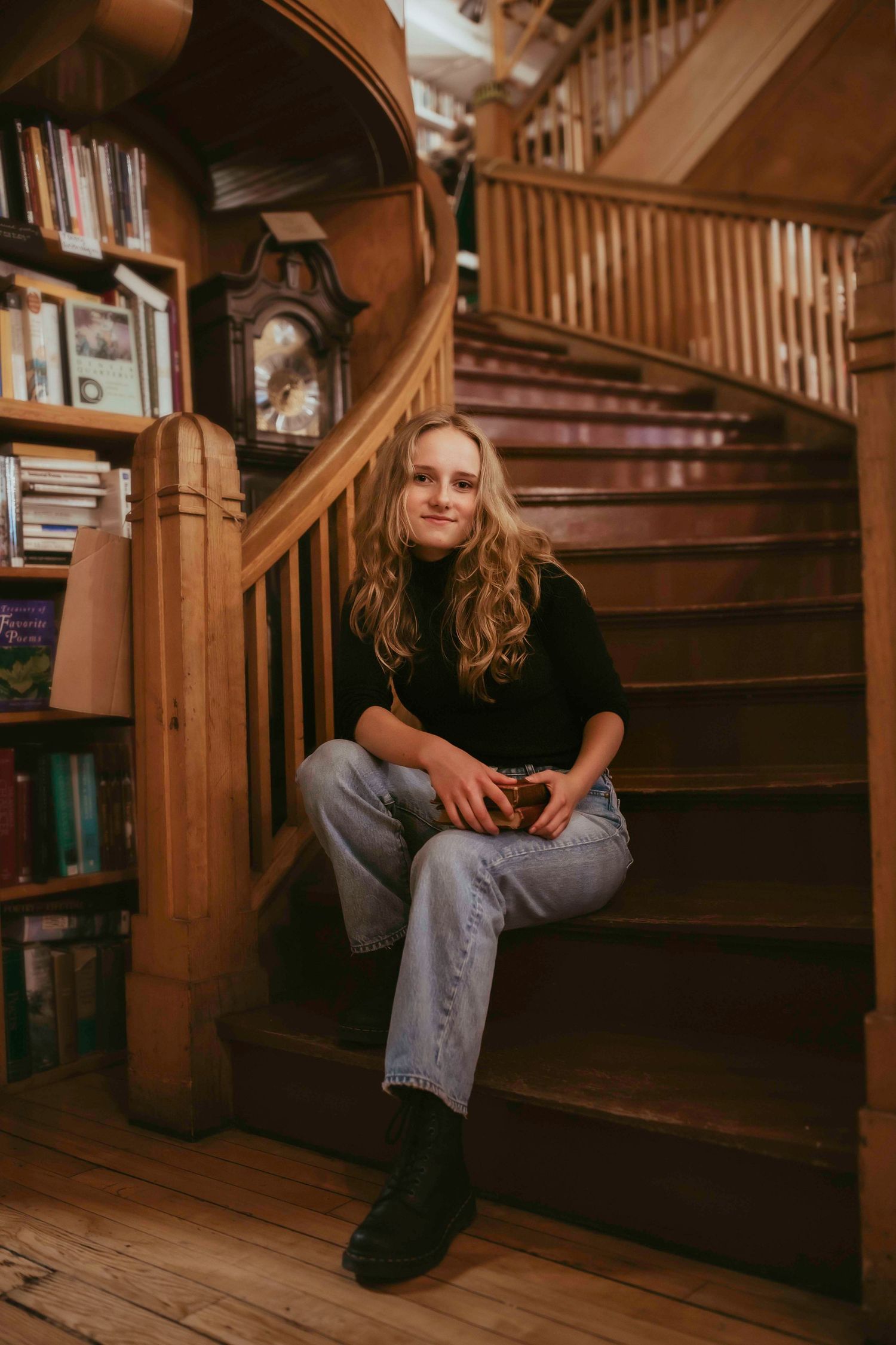 A relaxed pose on wooden stairs in a classic library with vintage details.