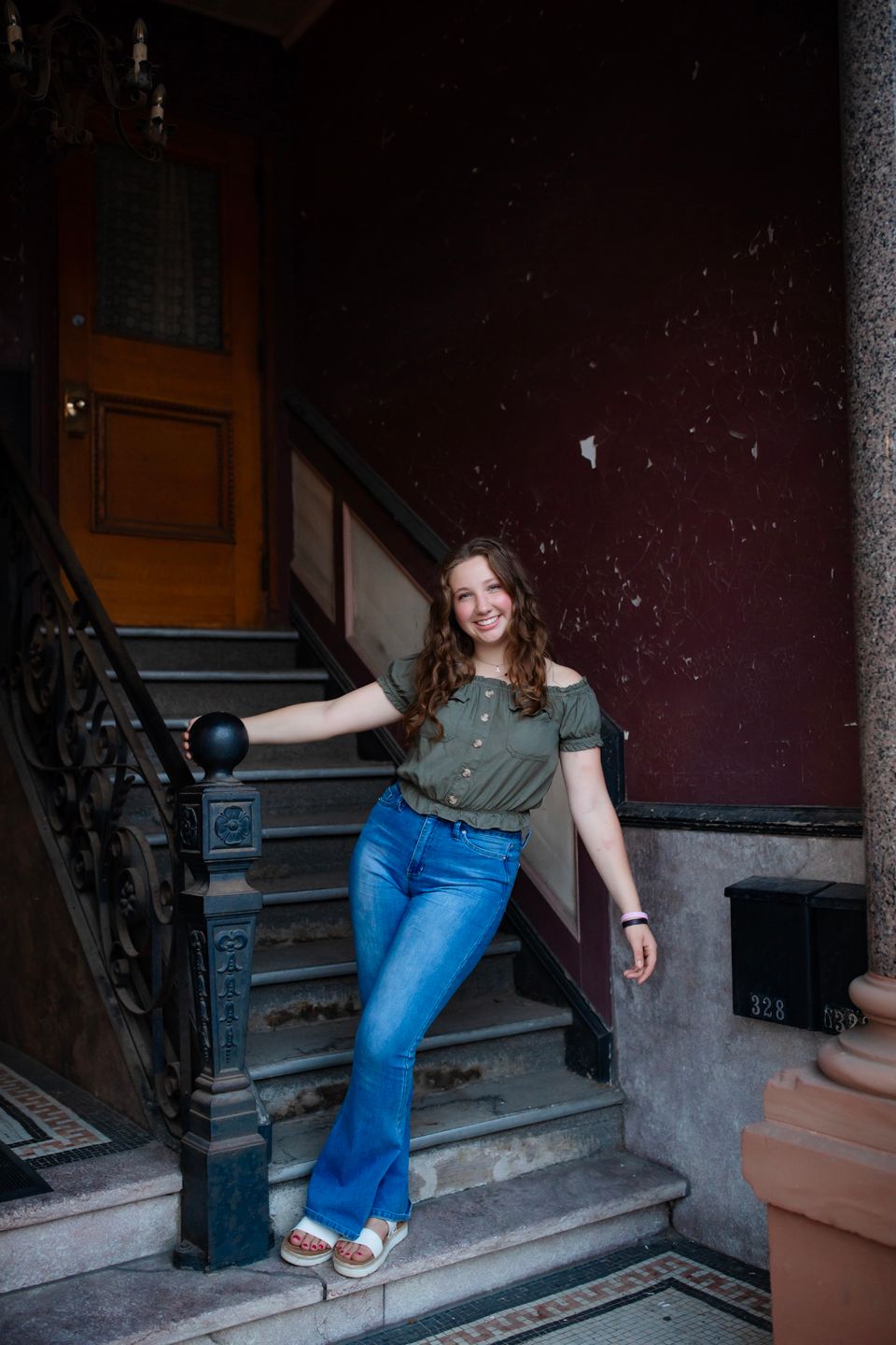 Person posing on vintage staircase in jeans and t-shirt.