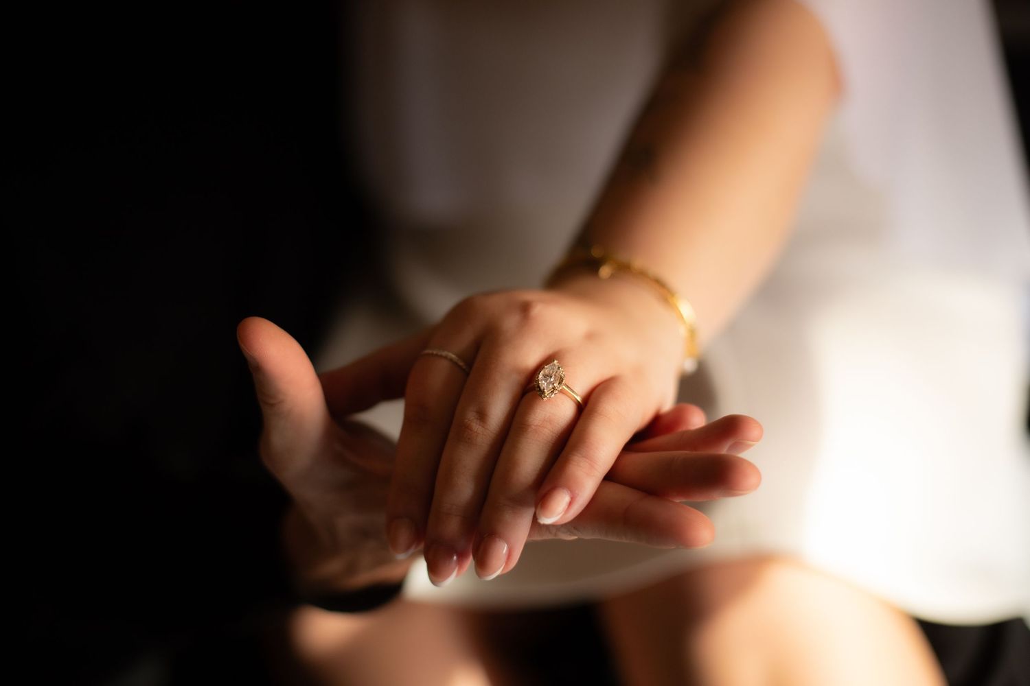 Hands holding and exchanging a small white business card in a professional setting.