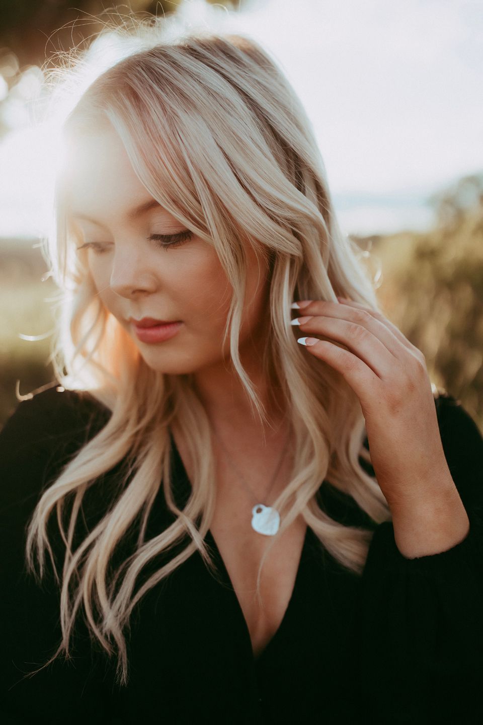 Intimate golden hour portrait with delicate necklace and soft lighting.