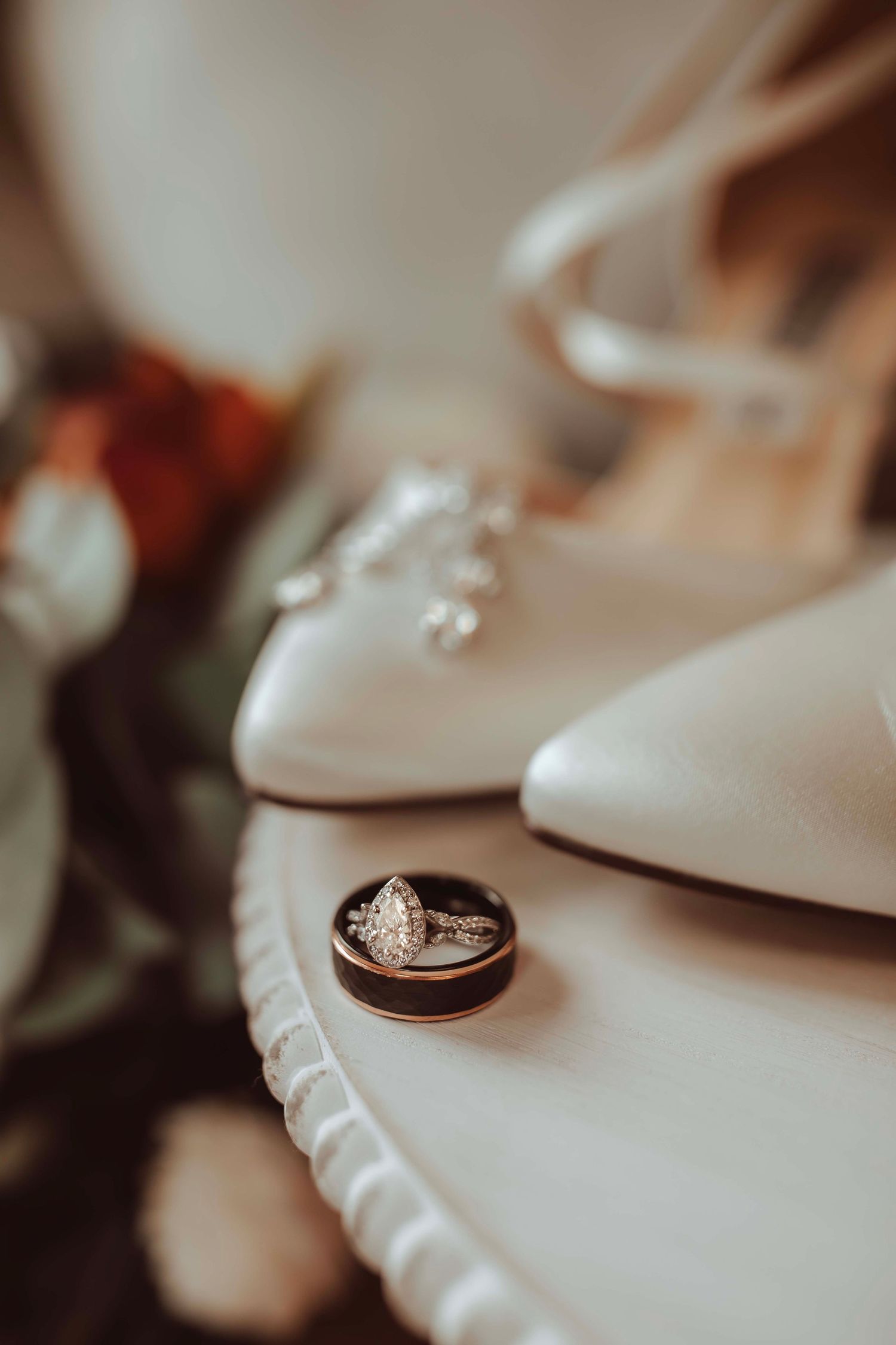 Wedding rings resting on a delicate lace surface in soft focus.