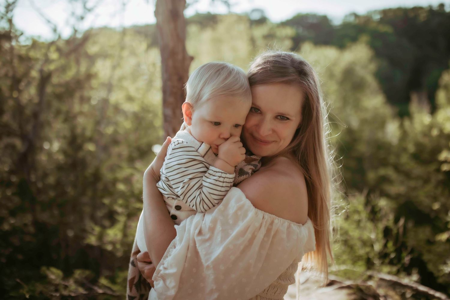 An intimate outdoor portrait with soft natural lighting in a wooded setting.
