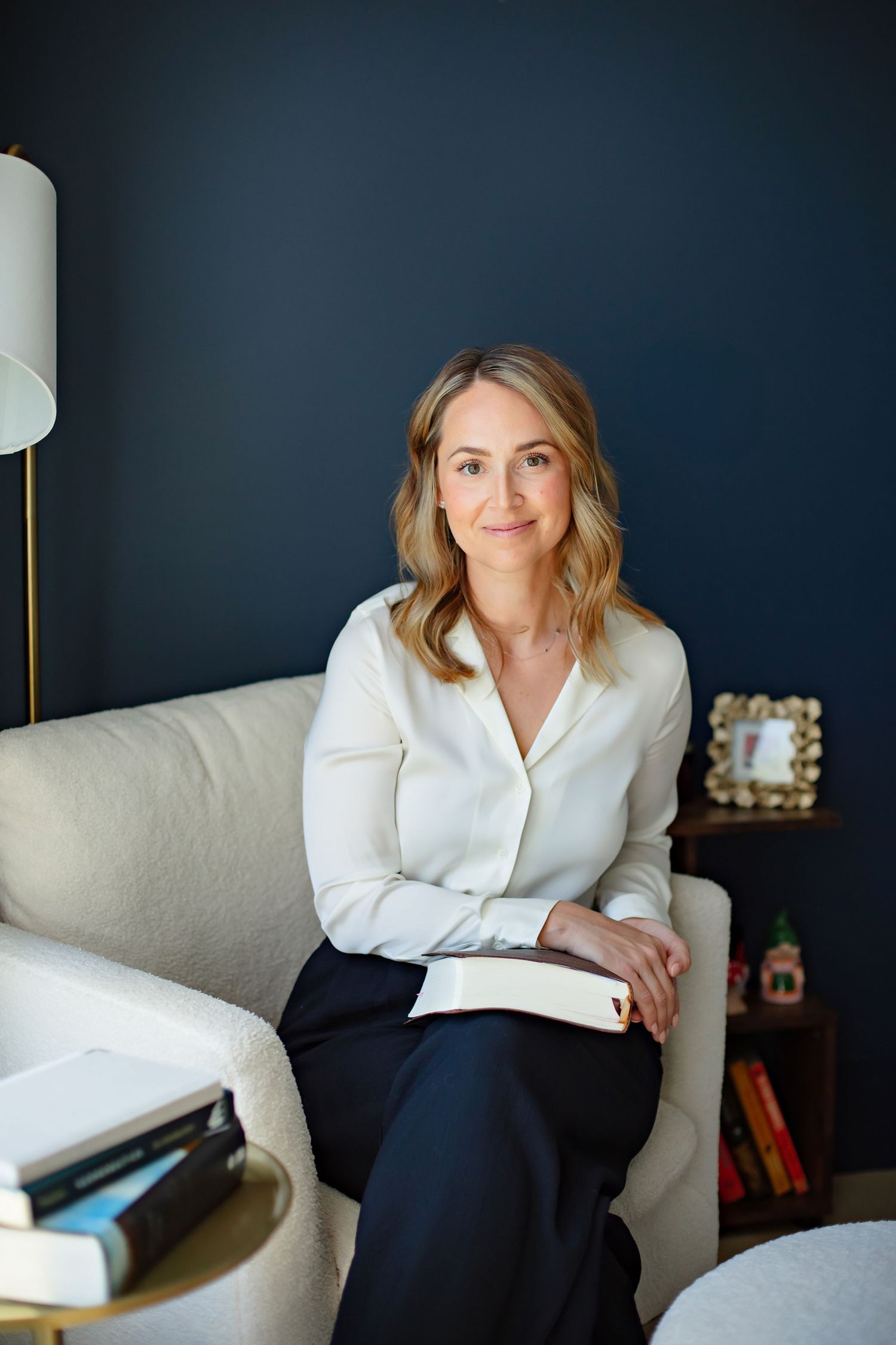 Professional office setting with dark navy walls and cream colored chair.