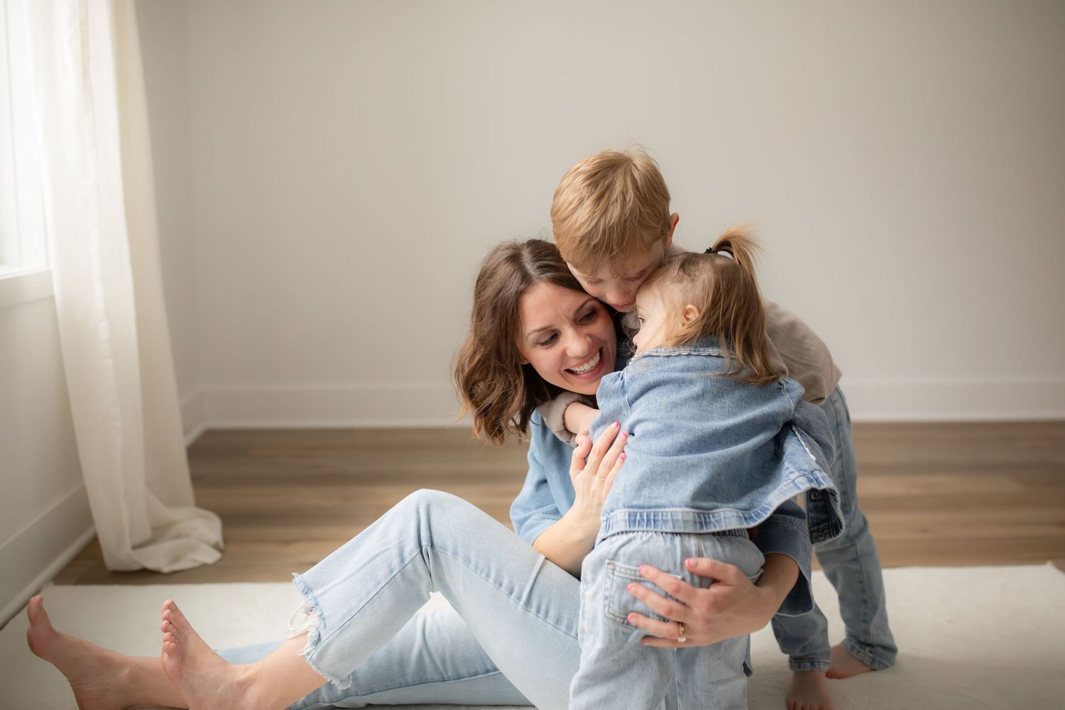 Candid moments of family bonding and laughter during relaxed indoor photography session.
