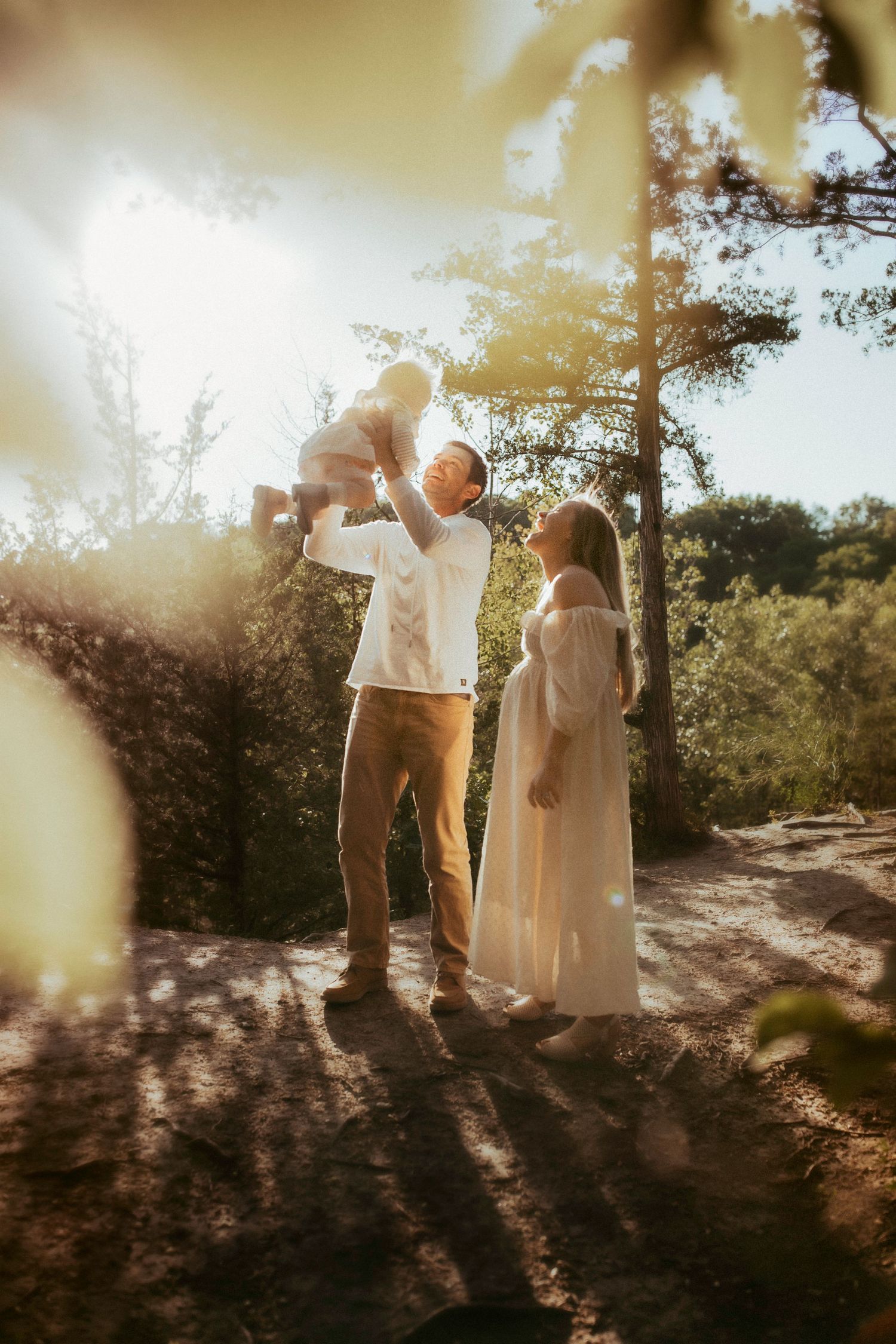 A backlit family silhouette in a forest setting during golden hour.