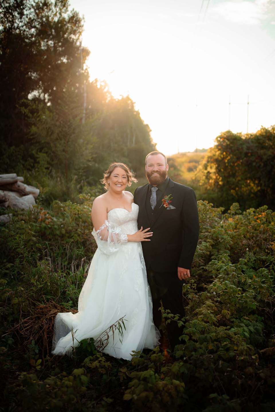 A sunset wedding portrait in a lush garden setting with golden light streaming through.