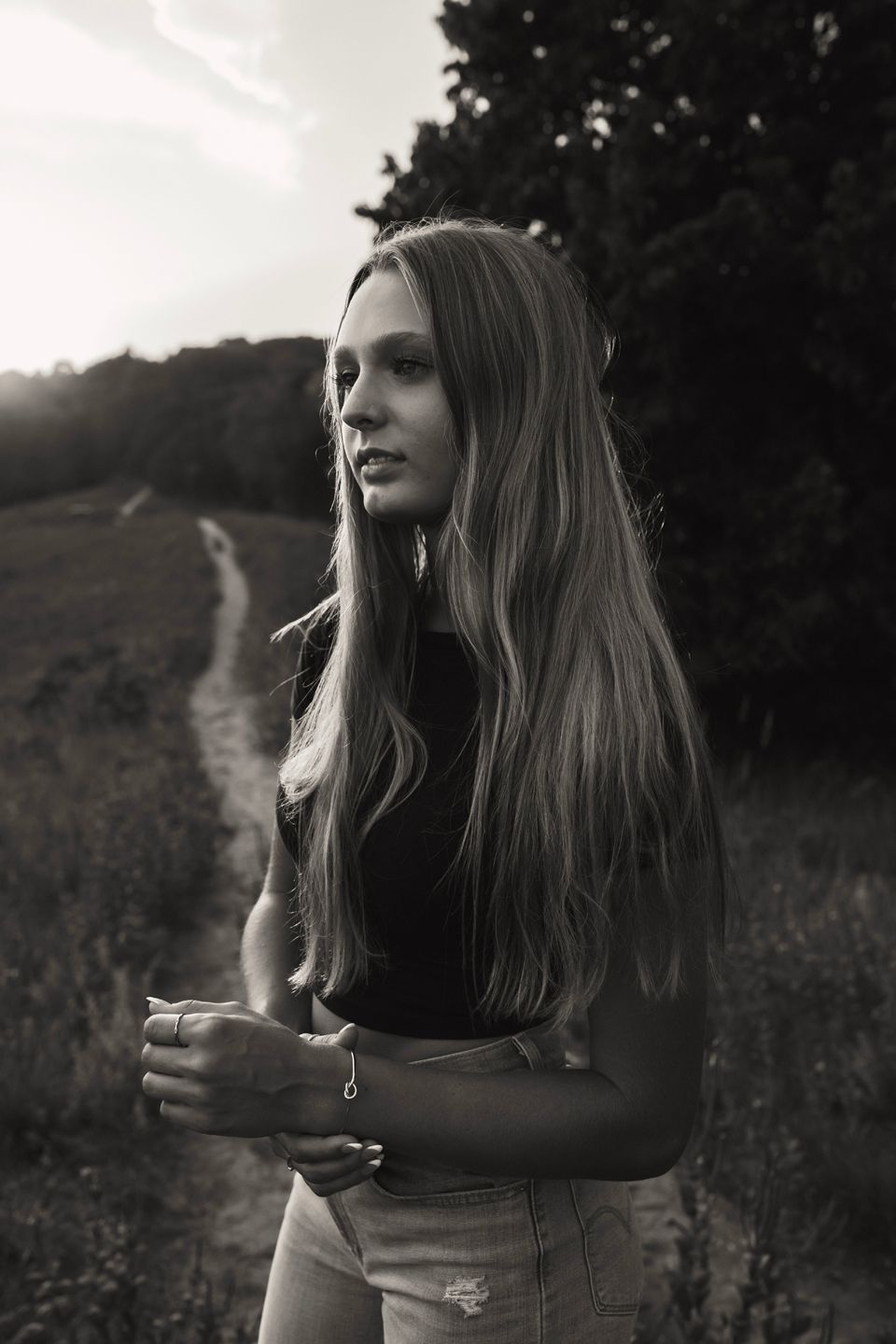 Black and white portrait of someone with long hair in natural lighting.