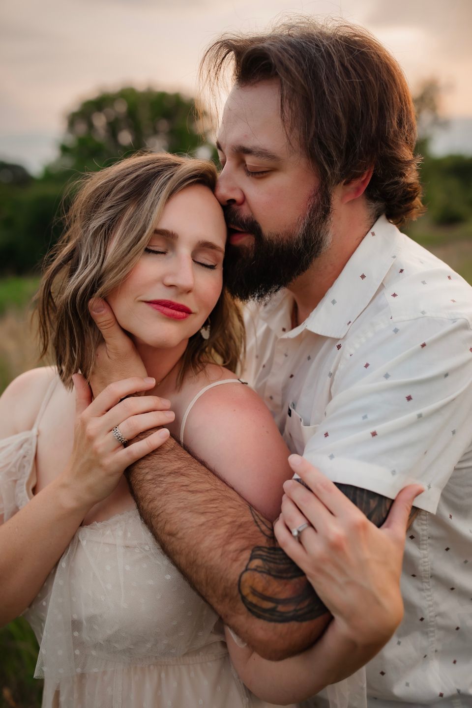 Intimate embrace captured between couple in warm sunset lighting.
