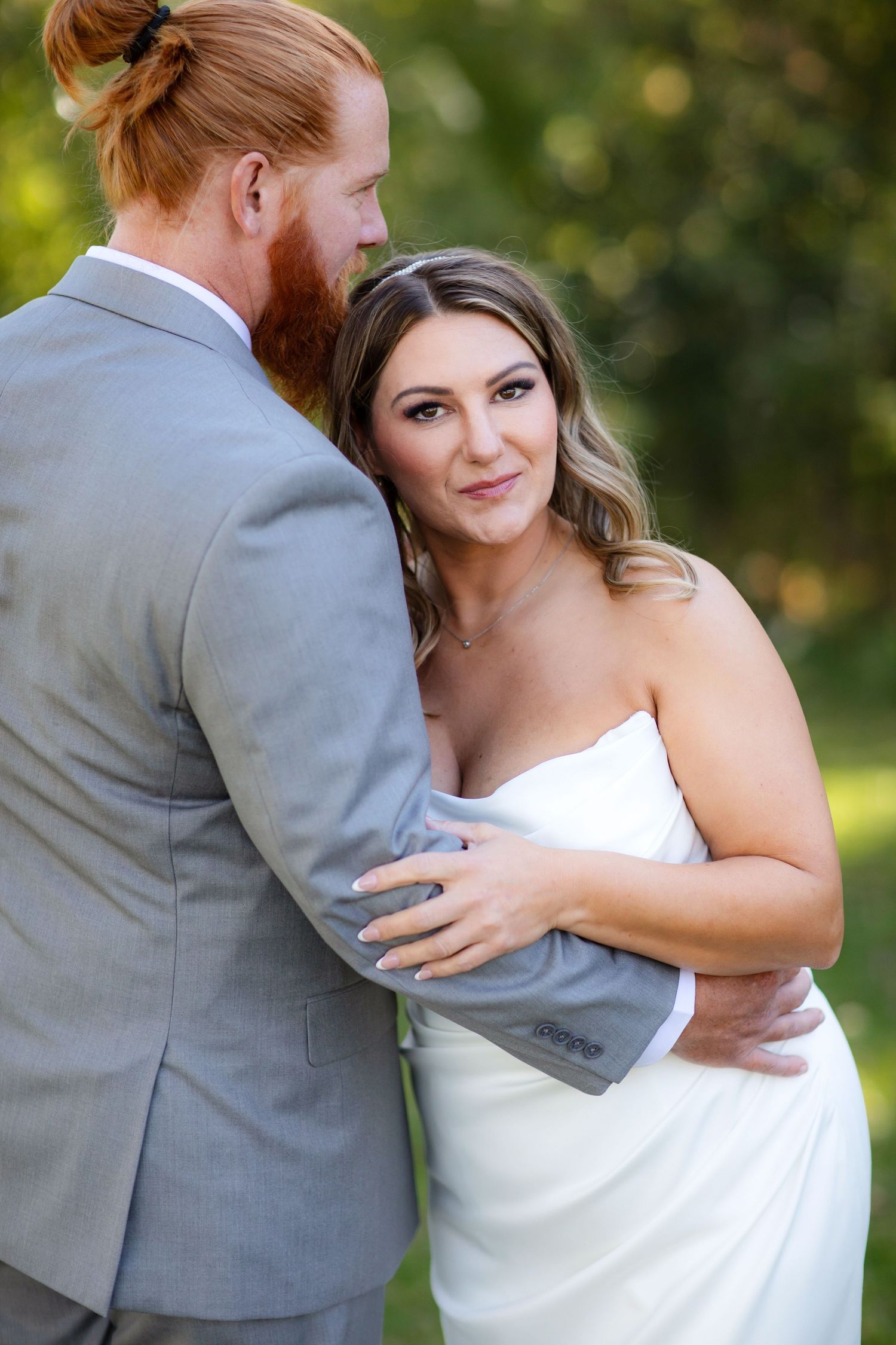 A romantic wedding couple embraces in a series of candid outdoor photos showing tender moments.