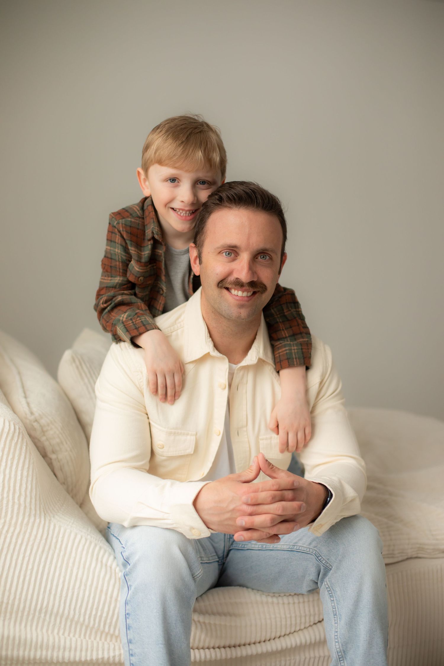 A series of candid moments showing playful interactions on a white couch against a neutral background.