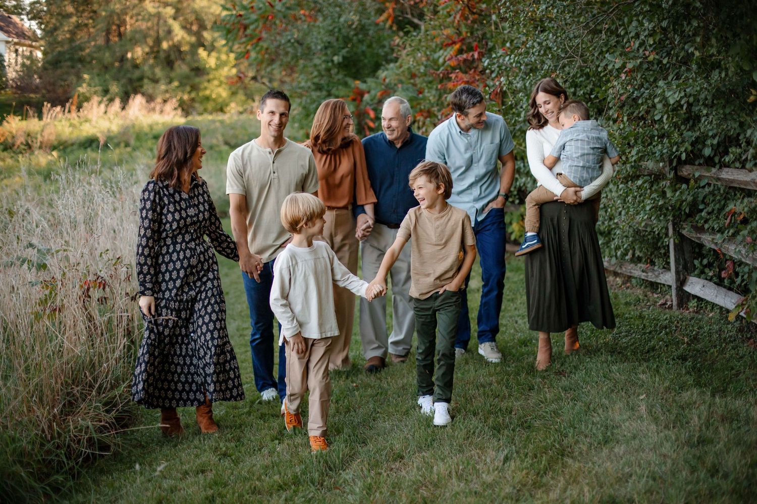 Group walking together on garden path during golden hour photo session.