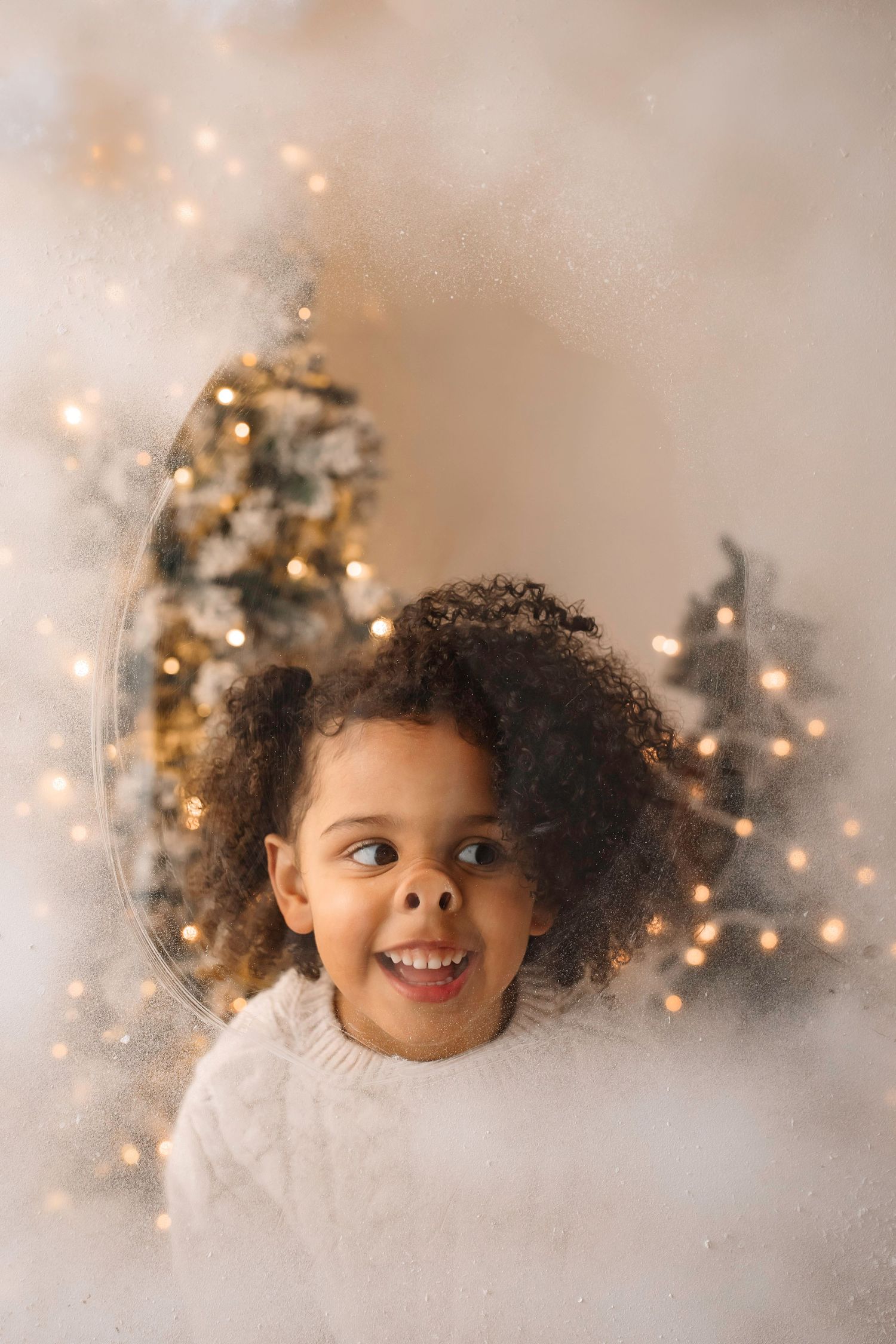 Festive winter portrait with Christmas trees twinkling in soft focus background.