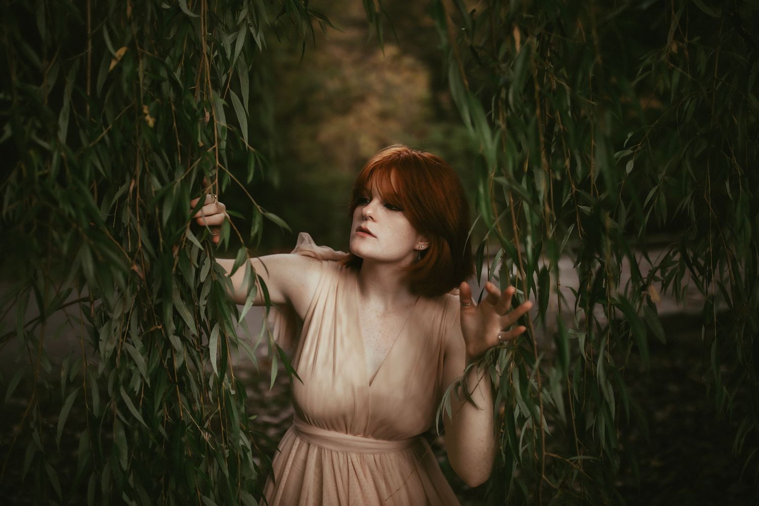 A dreamy scene in tall grass with a flowing peach dress and hanging glass orbs.