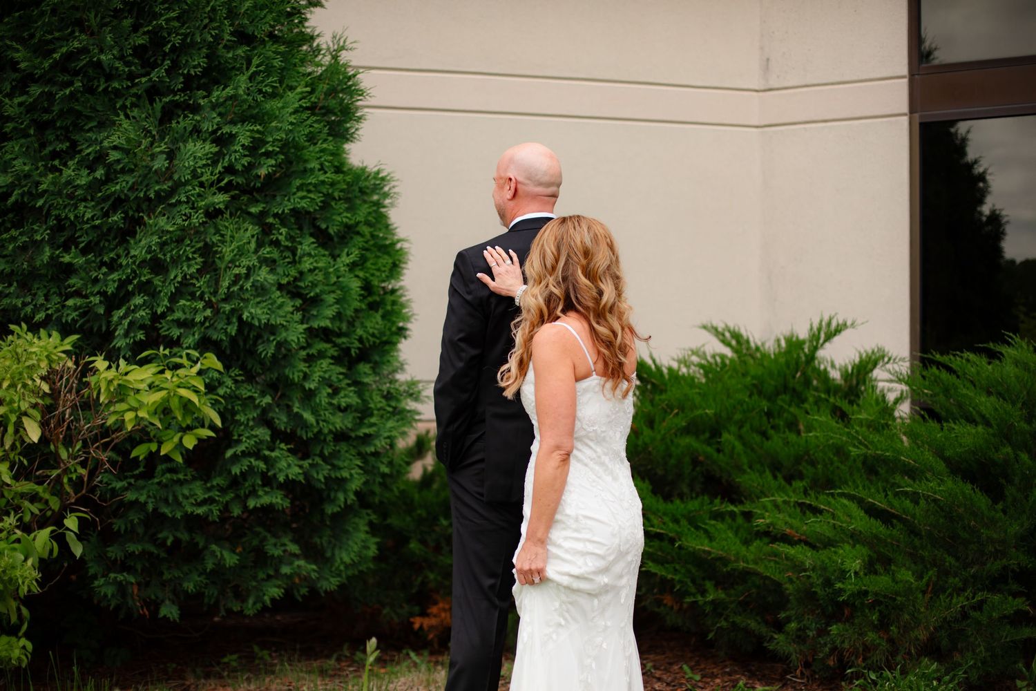 Bride and groom share an intimate moment in a lush garden setting during their wedding celebration.