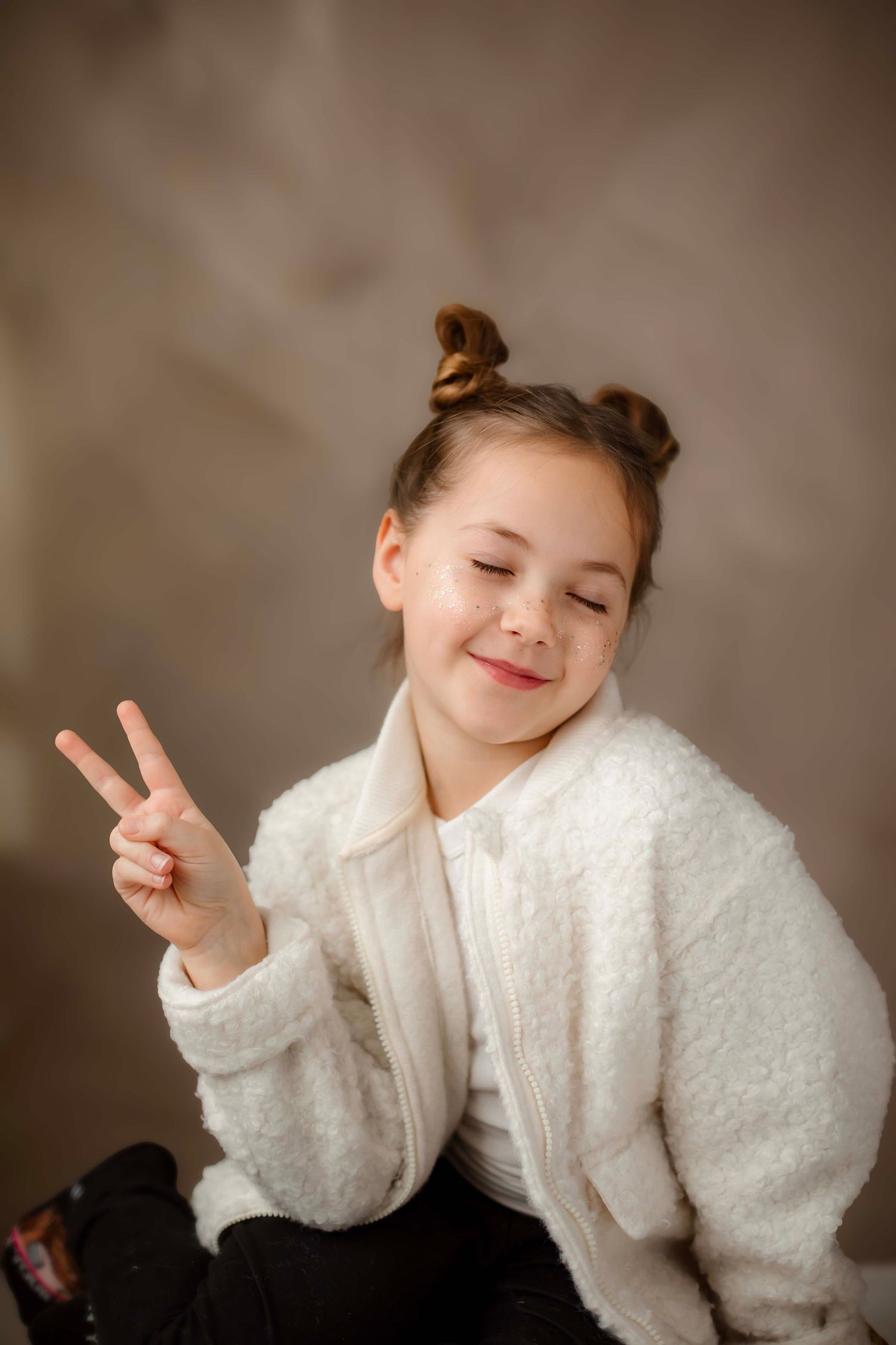 A series of expressive poses in a white fuzzy sweater against a brown backdrop shows playful movement and joy.