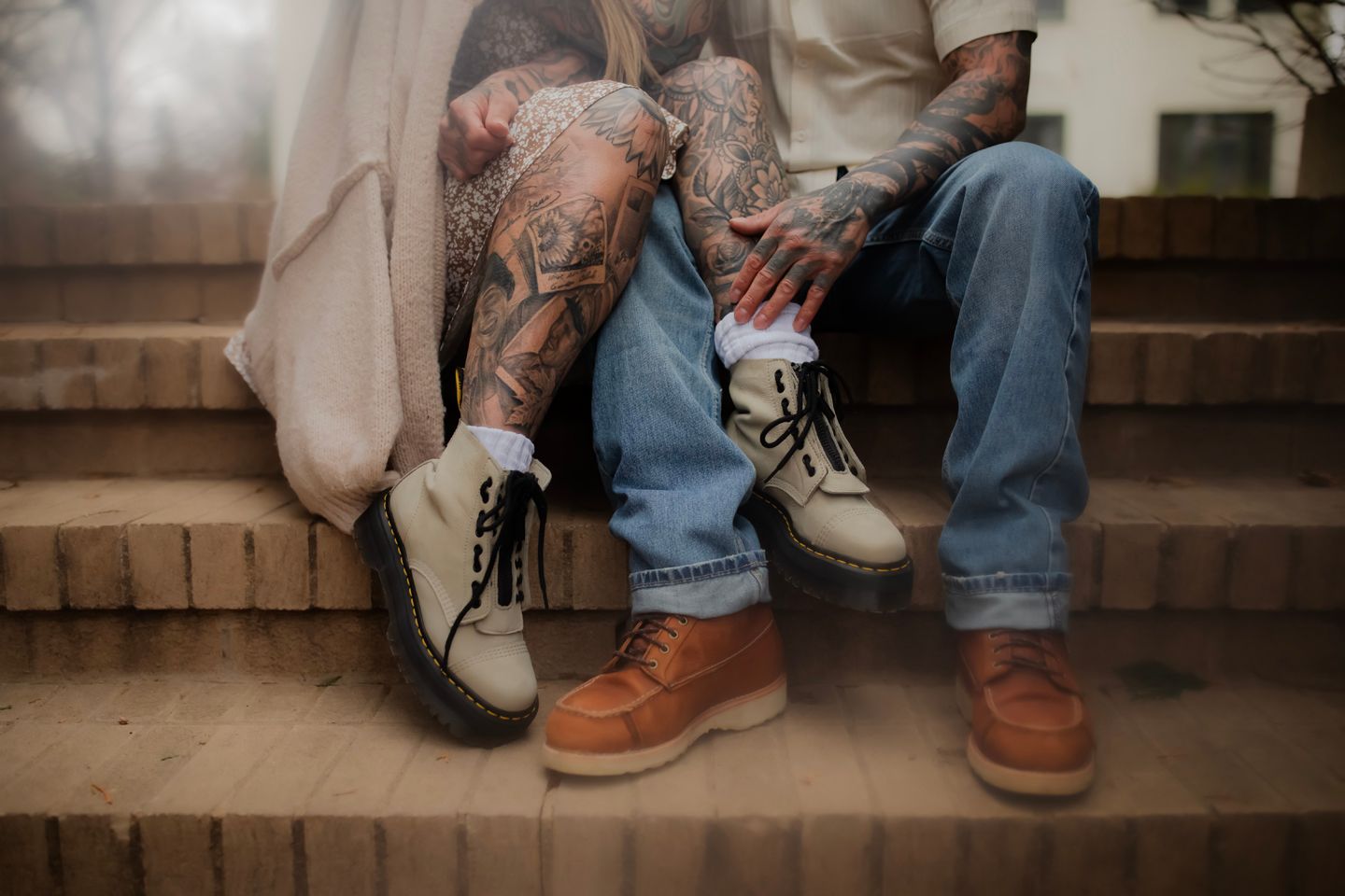 Close-up view of casual shoes and jeans on brick steps in warm vintage tones.
