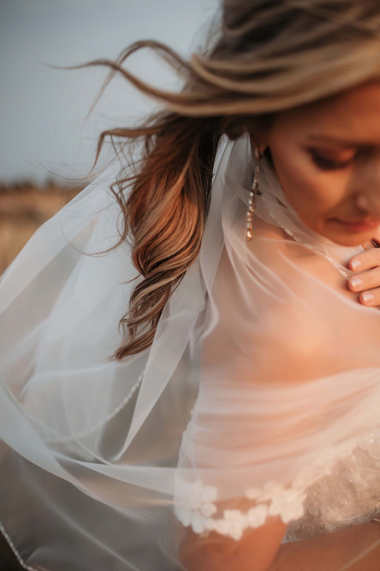 Close-up of bride's flowing veil and hair in golden sunset light.