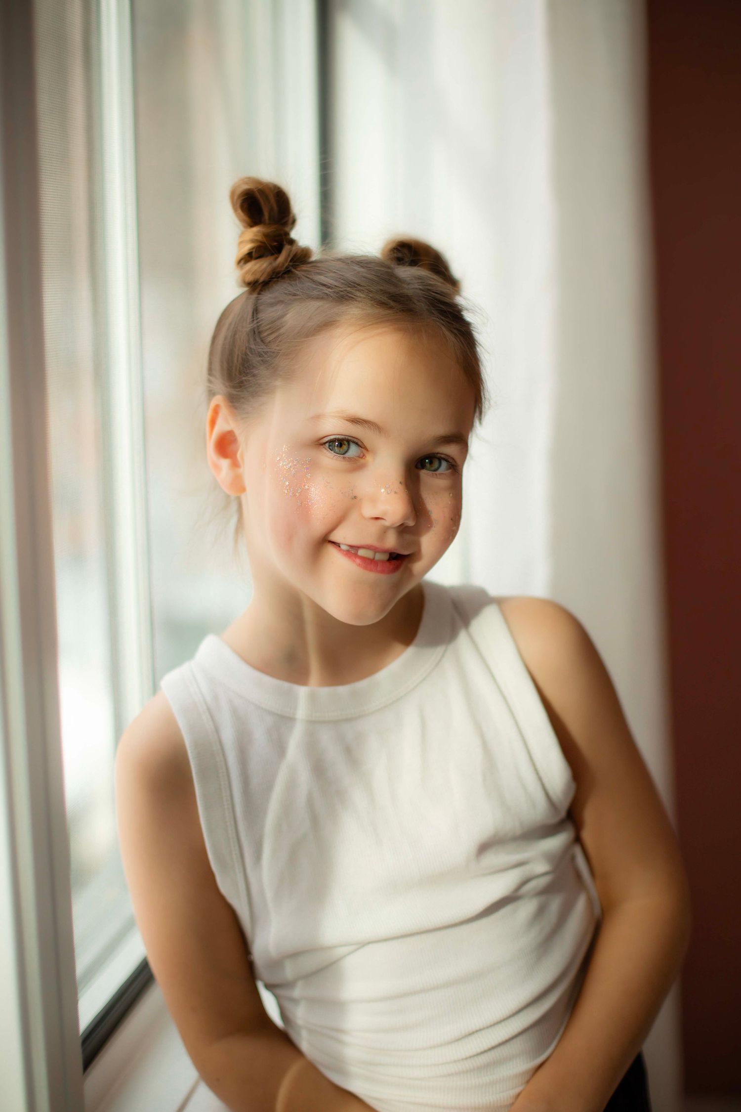 A series of three portraits showing joyful expressions against a bright window background.