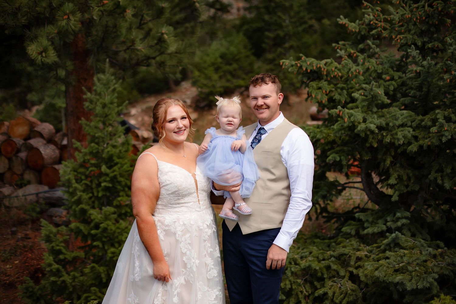 Wedding party poses outdoors in a garden setting with lush greenery and natural lighting.