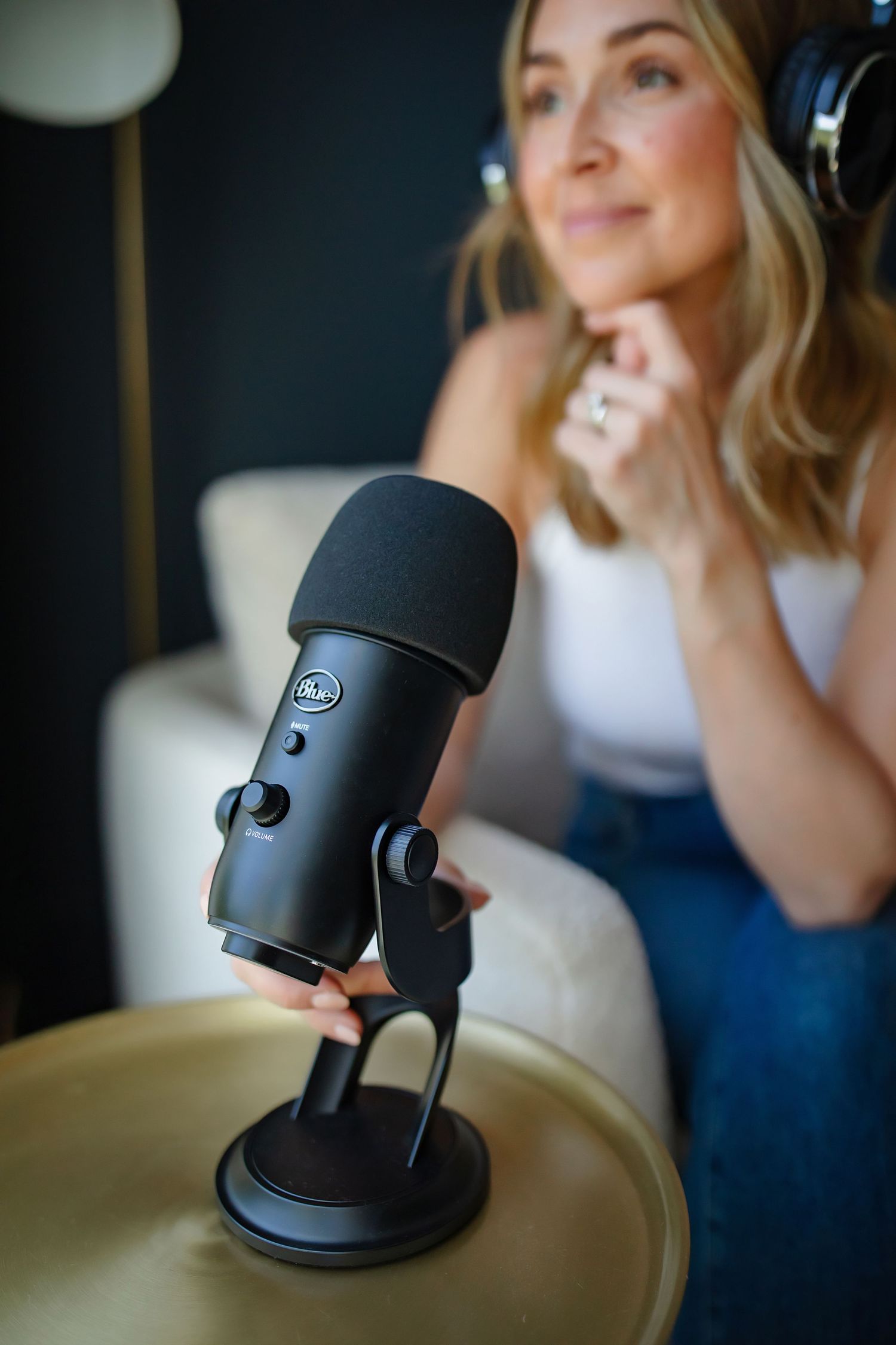 Blue Yeti microphone on stand with soft focus background in podcast recording setup.