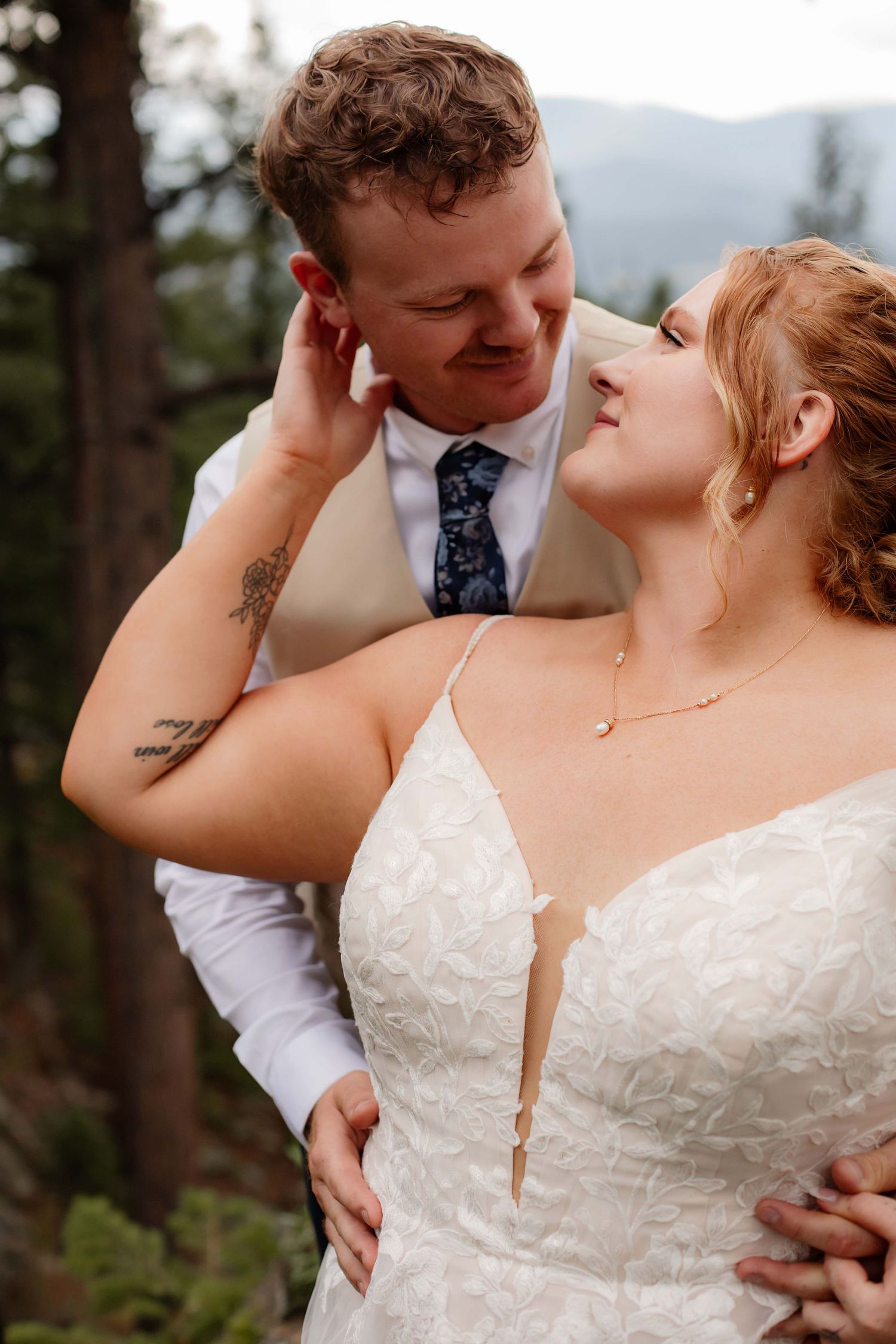 Romantic wedding portrait series showing intimate moments between newlyweds against forest backdrop.