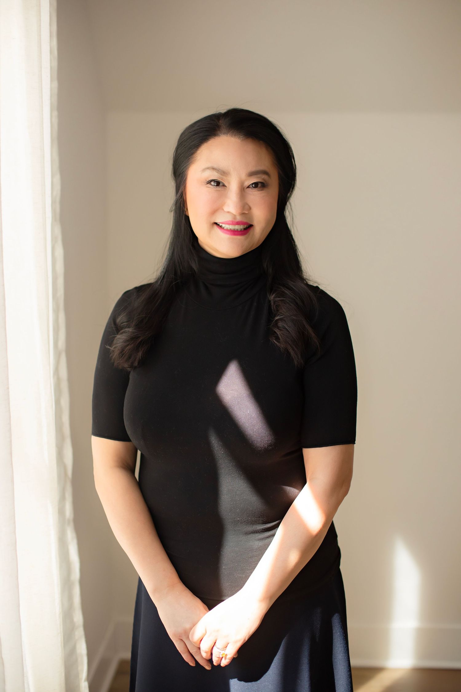 A series of portraits showing someone in a black top against a light wall with natural window lighting.