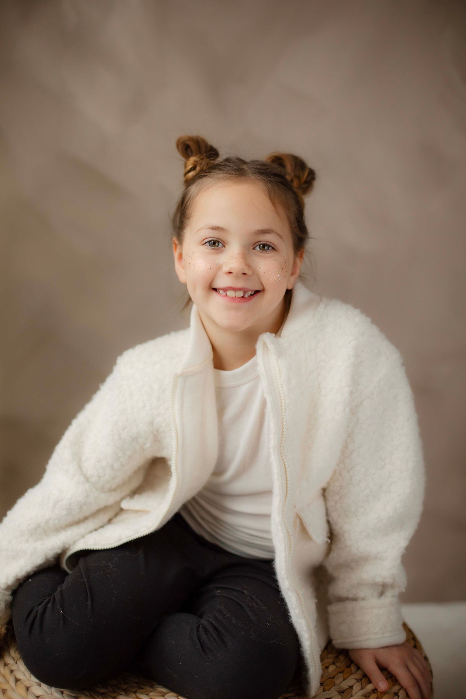 A series of portraits showing a child in a white sweater and dark pants against a neutral background.