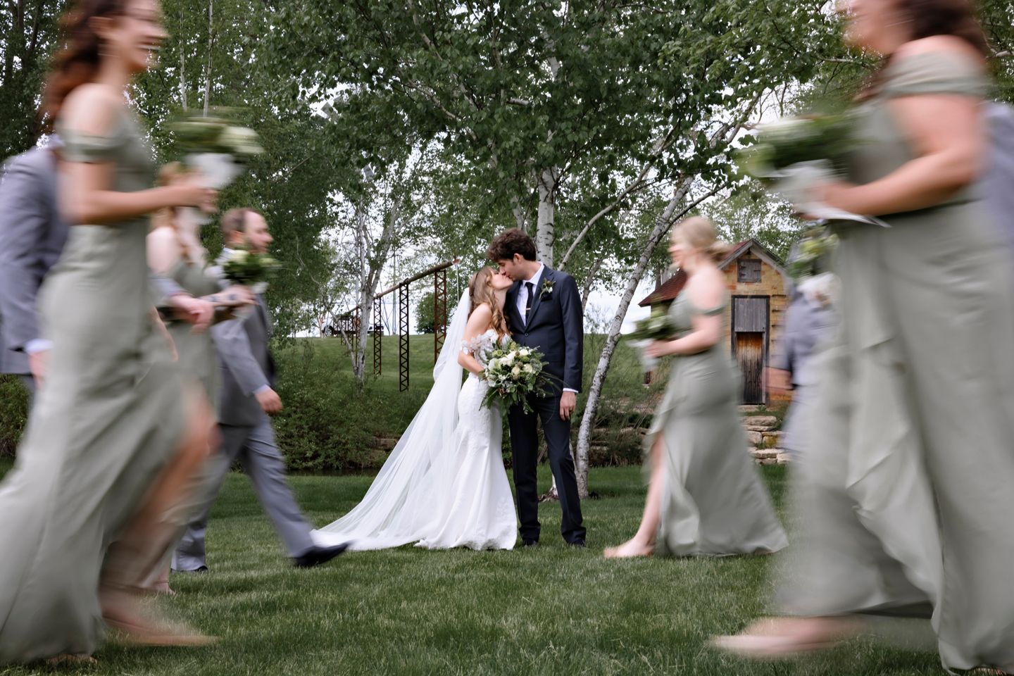 Wedding party members in gray create dynamic motion blur while dancing around the newlyweds.